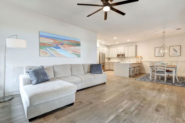 Living room featuring a ceiling fan, light wood-style floors, a chandelier, recessed lighting, and baseboards | Image 13