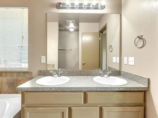 Bathroom with a tub to relax in, double vanity, a sink, and visible vents | Image 10