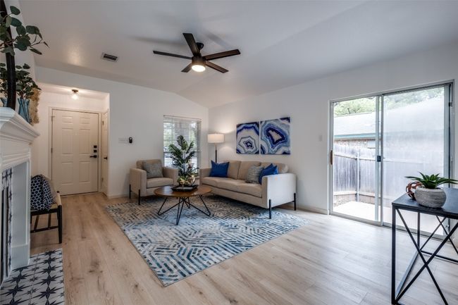 Living room with lofted ceiling, visible vents, light wood-type flooring, and ceiling fan | Image 4