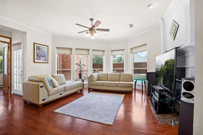 Living room featuring ceiling fan, dark wood-style flooring, crown molding, and recessed lighting | Image 13