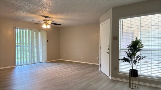 Spare room with wood finished floors, a ceiling fan, a textured ceiling, and baseboards | Image 4
