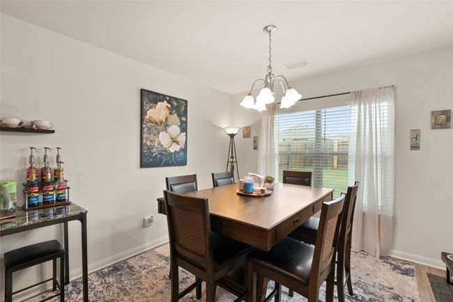 Dining room with inviting chandelier overlooking lush backyard | Image 12