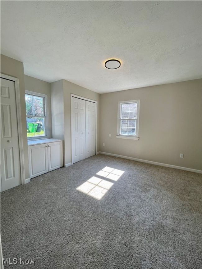Unfurnished bedroom with carpet flooring, multiple windows, and a textured ceiling | Image 20