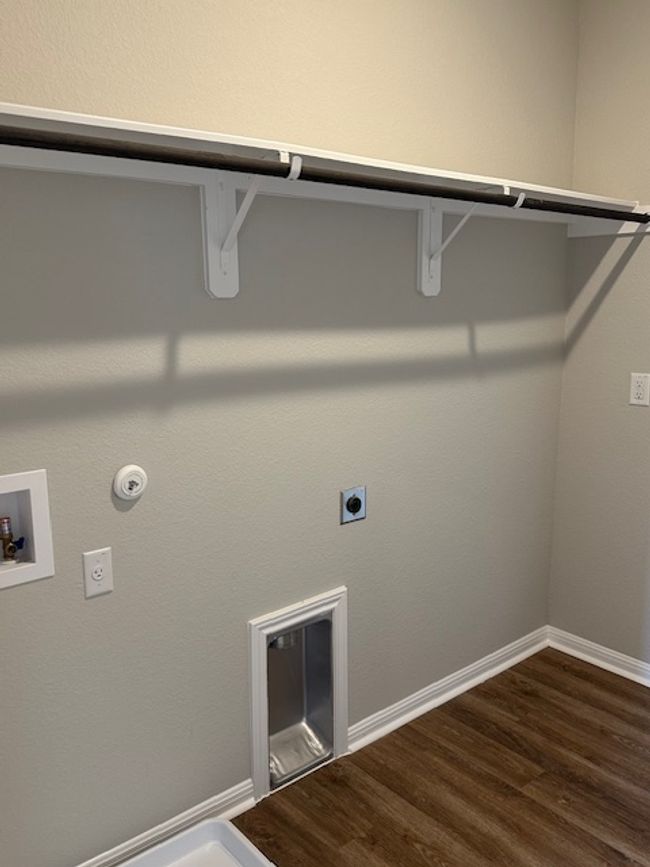 hookup for a washing machine, dark wood finished floors, and baseboards | Image 25