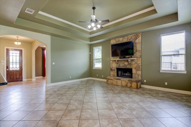 Spacious Family Room with tile flooring, stone fireplace and adjustable tv mount | Image 9