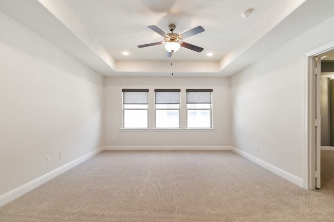 Unfurnished room with baseboards, a ceiling fan, light colored carpet, and a raised ceiling | Image 22