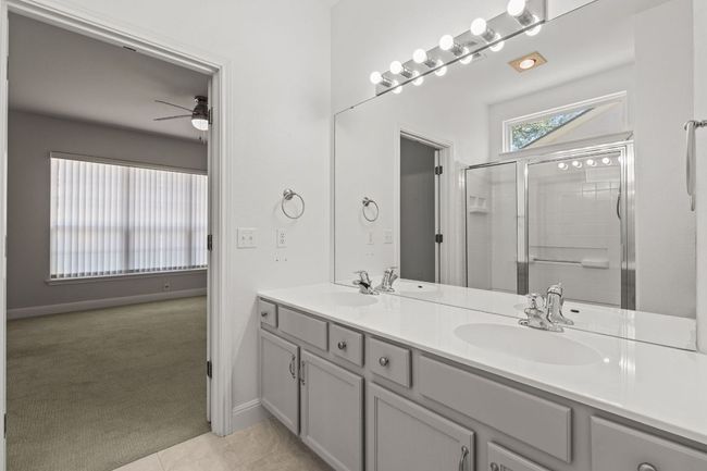 Full bath with double vanity, a sink, a stall shower, and a ceiling fan | Image 23