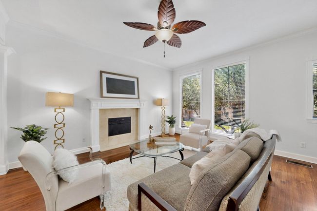 Living room featuring crown molding, wood finished floors, ceiling fan, and a premium fireplace | Image 4