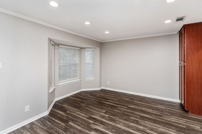 Empty room with dark wood-style floors, recessed lighting, and crown molding | Image 10