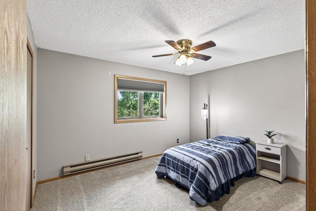 The second bedroom is just off the dining room and features newer carpet, a ceiling fan, and a new Anderson window. | Image 10