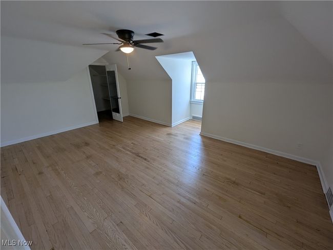 Bonus room with a ceiling fan, baseboards, vaulted ceiling, and light wood-style flooring | Image 23