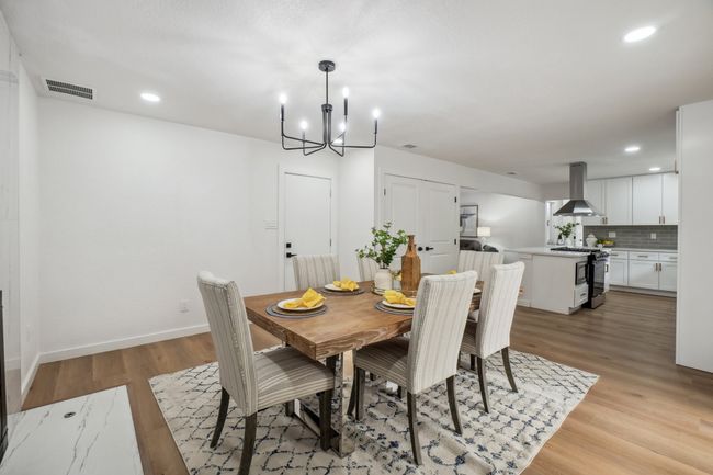 Dining space with light wood finished floors, a chandelier, recessed lighting, and baseboards | Image 10