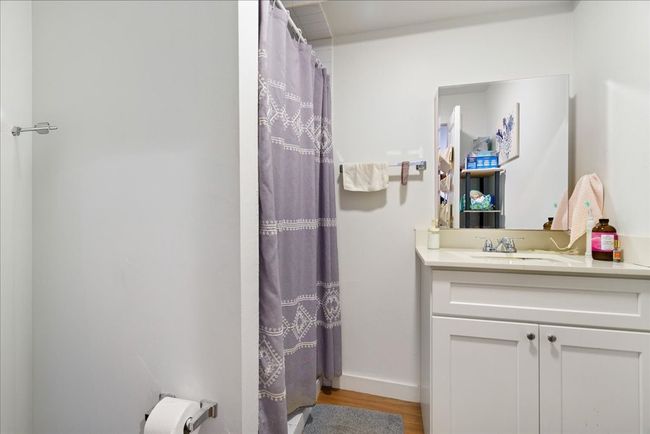 The en-suite bathroom contains a vanity with cabinet space and laminate flooring throughout. | Image 10