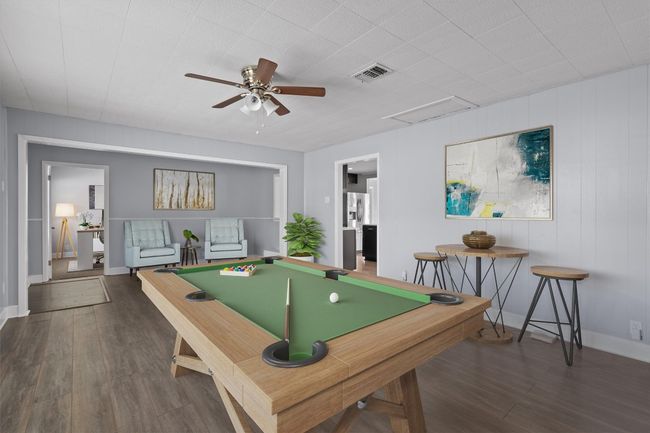 Recreation room with wood finished floors, visible vents, a ceiling fan, attic access, and pool table | Image 5