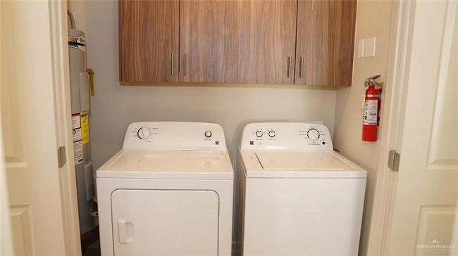 Laundry area with separate washer and dryer, cabinet space, and water heater | Image 19