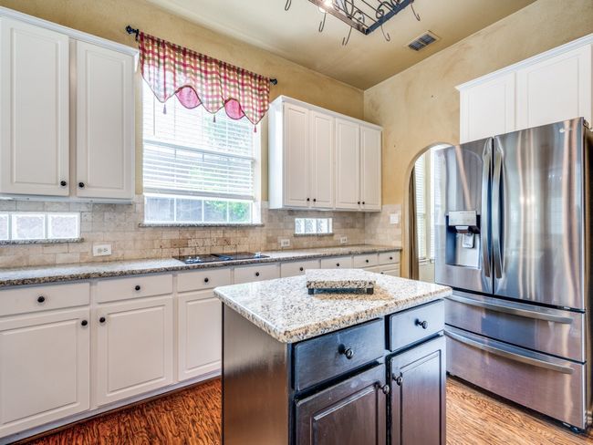 Kitchen featuring white cabinetry, backsplash, and granite counters | Image 14