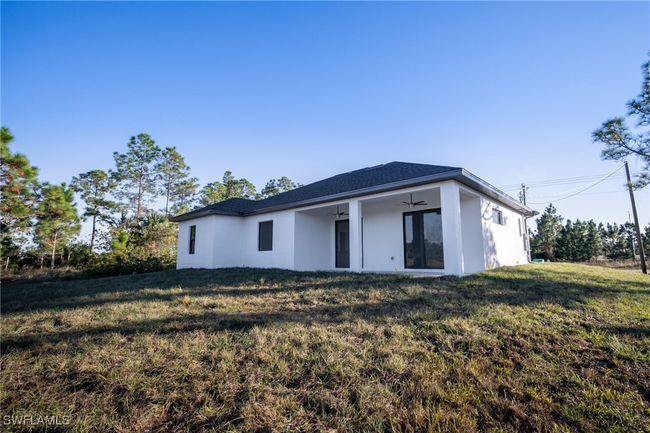 Rear view of property with ceiling fan and a lawn | Image 24