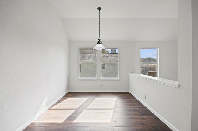 Unfurnished dining area with wood finished floors and lofted ceiling | Image 4