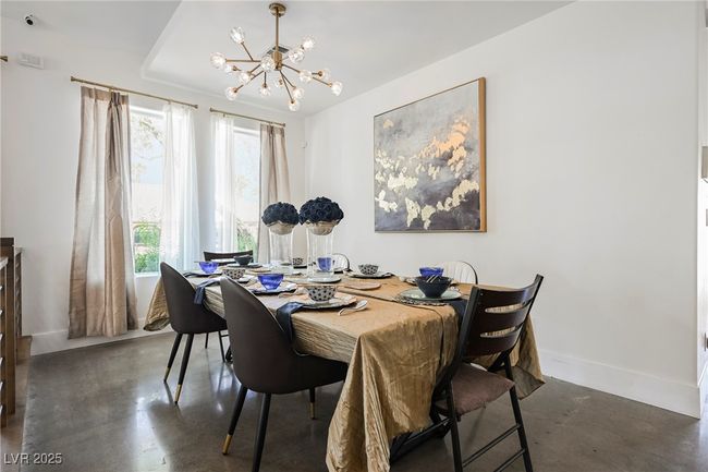 Dining room featuring a chandelier, concrete floors, and baseboards | Image 11