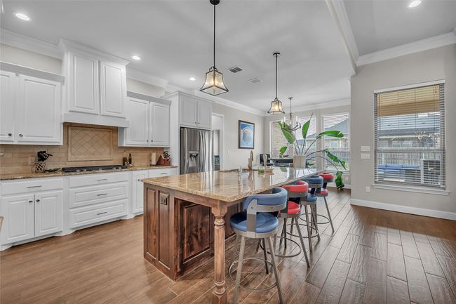 Kitchen with stainless steel appliances, wood finished floors, recessed lighting, backsplash, and ornamental molding | Image 11