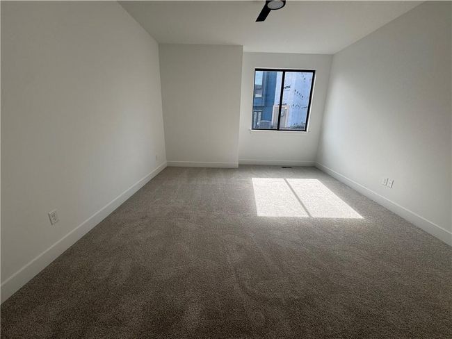 Empty room featuring light colored carpet, ceiling fan, and baseboards | Image 13