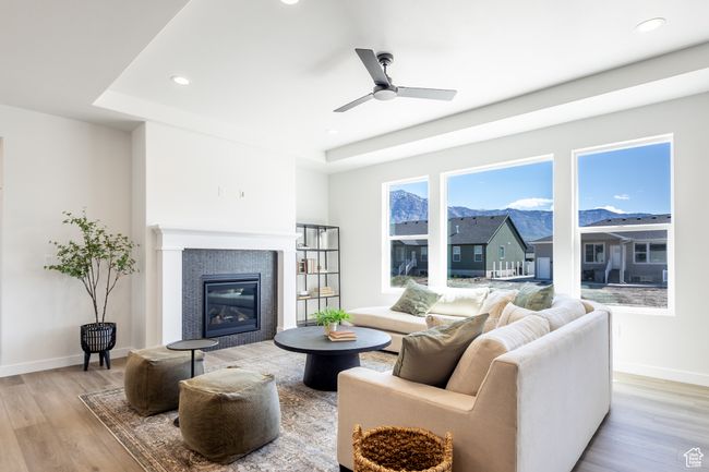 Living area featuring light wood-style flooring, a tile fireplace, baseboards, recessed lighting, and a ceiling fan | Image 8