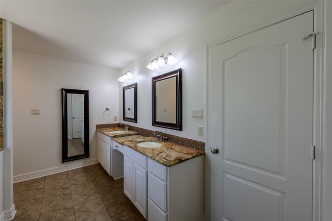 Full bathroom with double vanity, baseboards, and a sink | Image 12