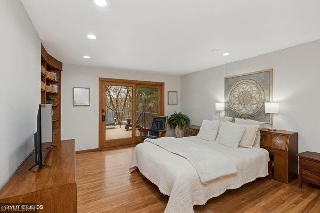 Primary bedroom has wood floors and a patio door that leads the large backyard deck. Perfect for morning coffee! | Image 27