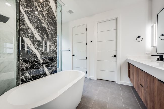 Full bath with a soaking tub, vanity, and tile patterned flooring | Image 25