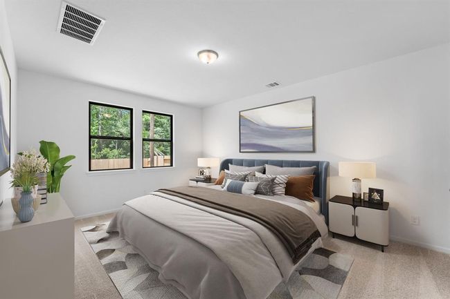 The primary bedroom is generously sized, creating a tranquil and spacious retreat that offers ample room for relaxation. Featuring plush carpet, high ceilings, fresh paint, and large windows that lets in natural lighting throughout the day. | Image 11