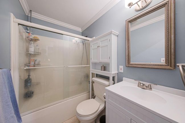 Bathroom with vanity, toilet, enclosed tub / shower combo, and ornamental molding | Image 34