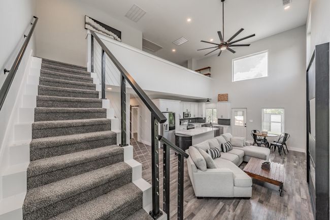 Living area featuring a ceiling fan, stairway, wood finished floors, recessed lighting, and baseboards | Image 20