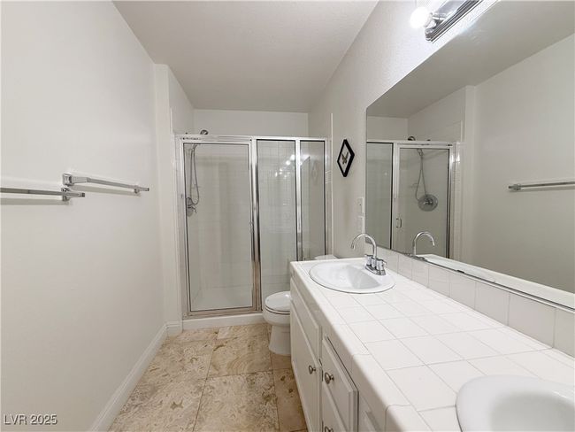 Bathroom with double vanity, a shower stall, toilet, and a sink | Image 36