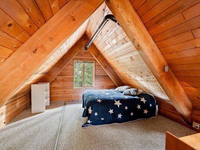 Bedroom with vaulted ceiling with beams, wood walls, carpet flooring, and wood ceiling | Image 28