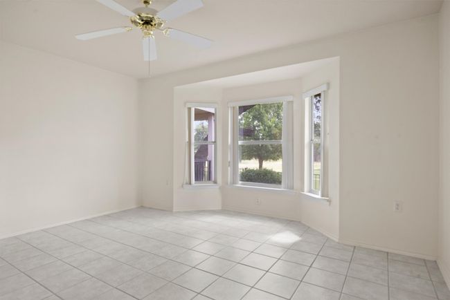 Empty room featuring light tile patterned flooring and ceiling fan | Image 16