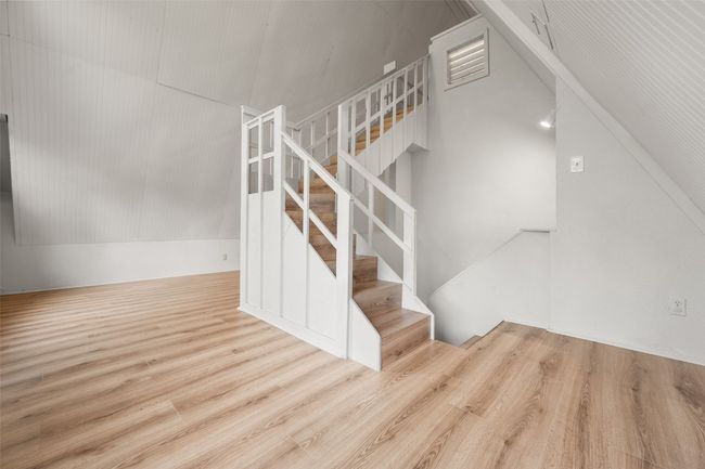Stairway with wood finished floors and high vaulted ceiling | Image 20