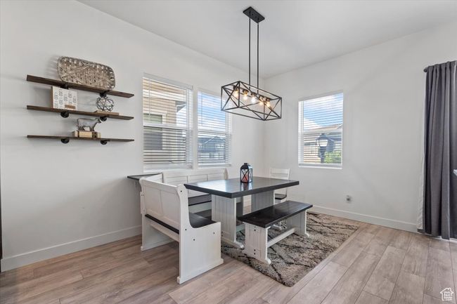 Dining area with light wood-style floors and a chandelier | Image 6