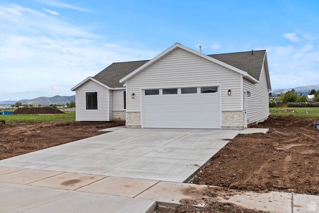 Ranch-style house with a shingled roof, stone siding, a garage, driveway, and a mountain view | Image 24