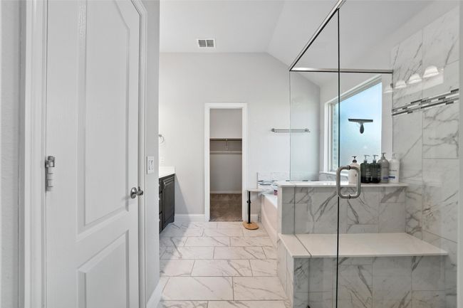 Bathroom featuring marble look tile flooring, vanity, a garden tub, a spacious closet, and lofted ceiling | Image 21
