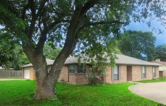 Ranch-style home featuring driveway, brick siding, and a garage | Image 4