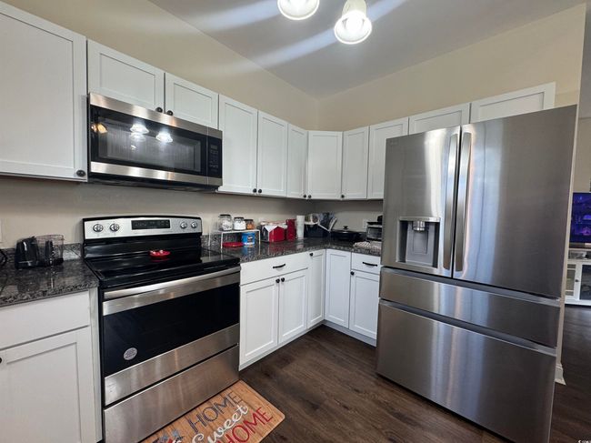 Kitchen featuring stainless steel appliances, dark wood finished floors, and white cabinets | Image 9