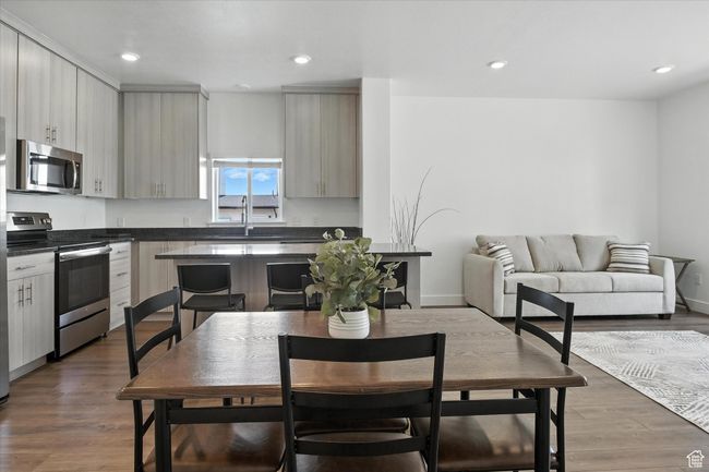 Kitchen with appliances with stainless steel finishes, dark countertops, wood finished floors, and recessed lighting | Image 5