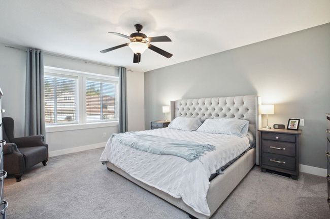 Bedroom with light carpet, ceiling fan, and baseboards | Image 18