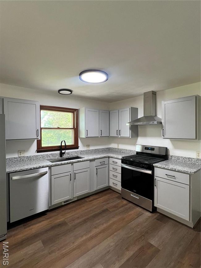 Kitchen featuring exhaust hood, dishwasher, stove, refrigerator, and a sink | Image 14