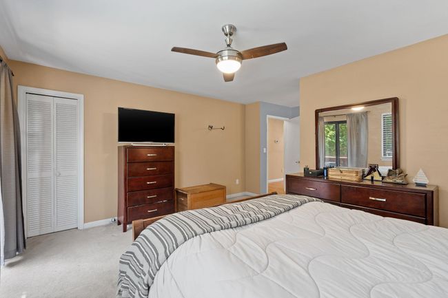 Bedroom featuring light carpet, baseboards, a closet, and ceiling fan | Image 6