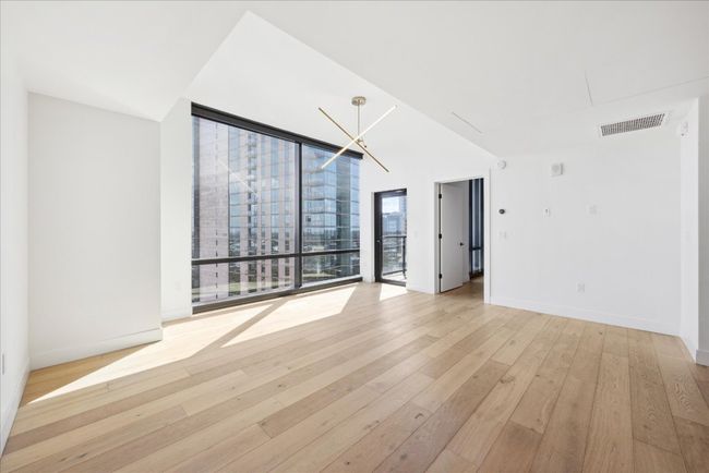 Spare room featuring light wood-style flooring and floor to ceiling windows | Image 4