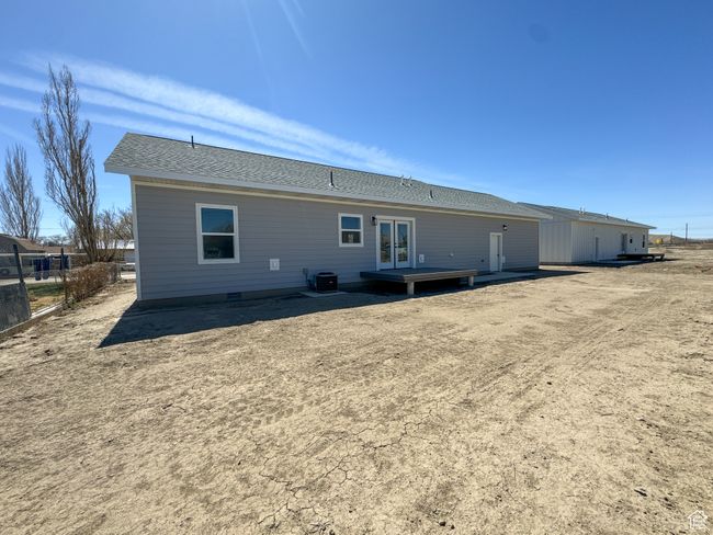 Rear view of property featuring french doors, a shingled roof, and cooling unit | Image 39