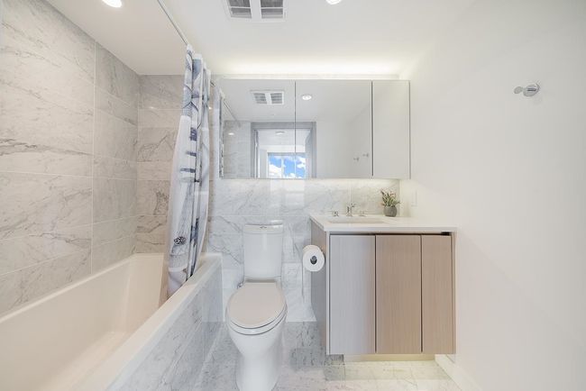 Full bathroom featuring toilet, shower / bath combo, vanity, recessed lighting, and tile walls | Image 11