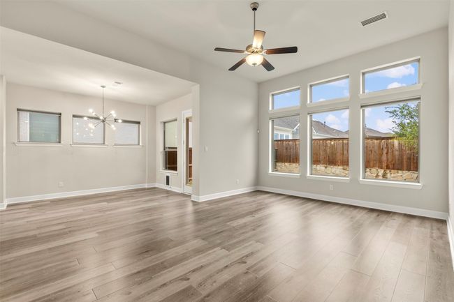 Unfurnished living room with a chandelier, wood finished floors, and baseboards | Image 11