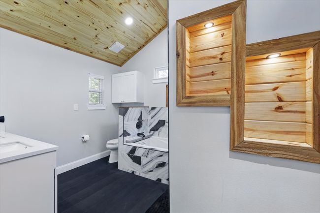 Bathroom featuring lofted ceiling, toilet, wood finished floors, wood ceiling, and baseboards | Image 26
